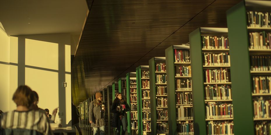 Students walking through the stacks at Charles Library