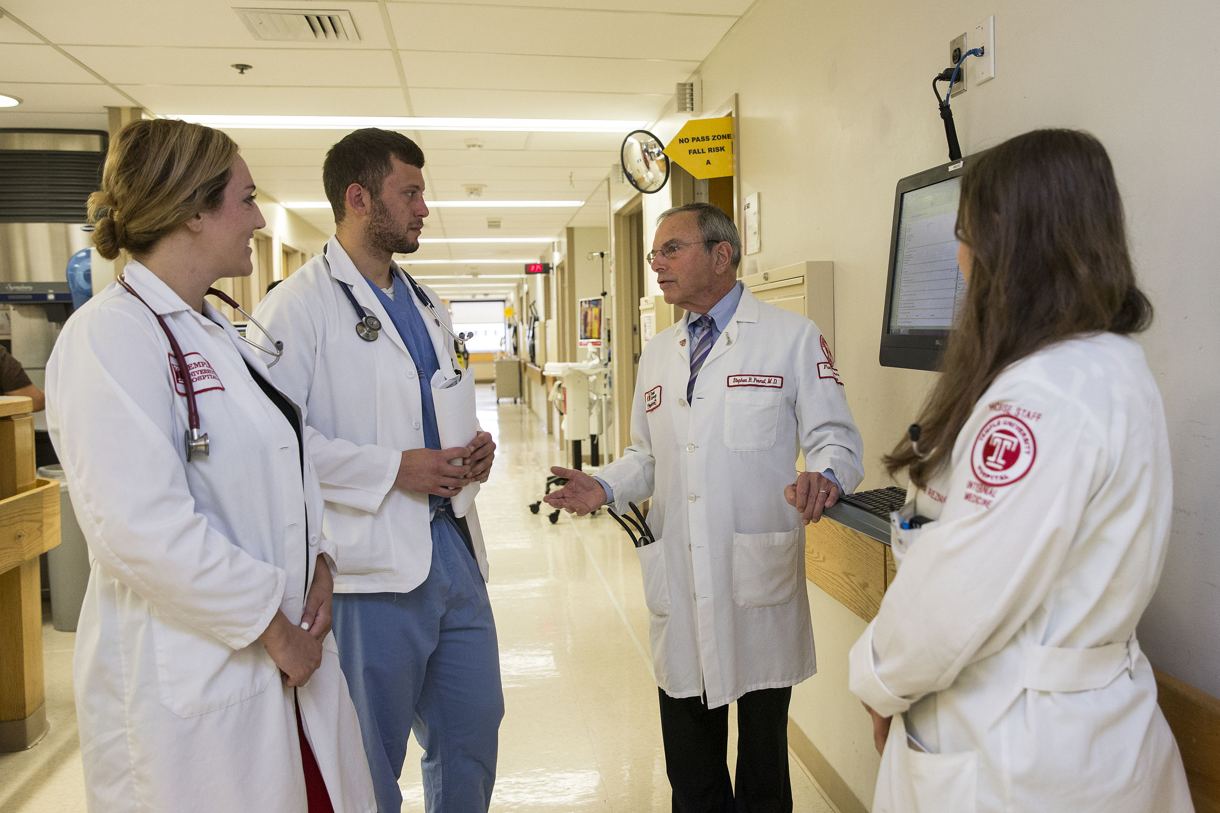 Medicine students talk to a faculty physician in the Temple University hospital.