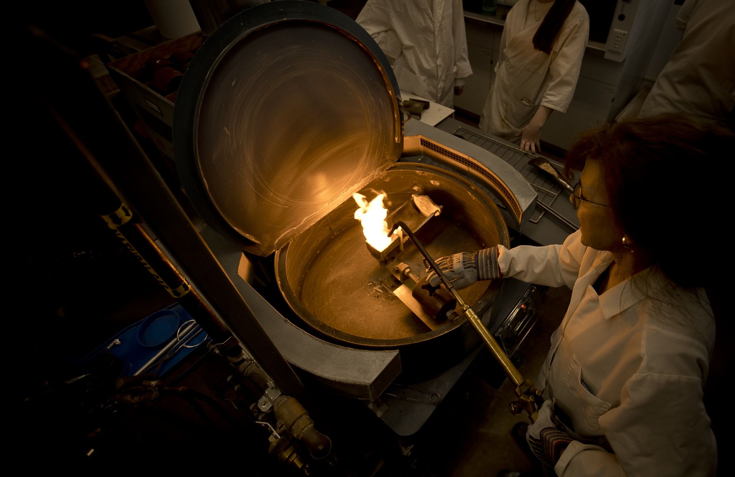 A Tyler art student works with a furnace.