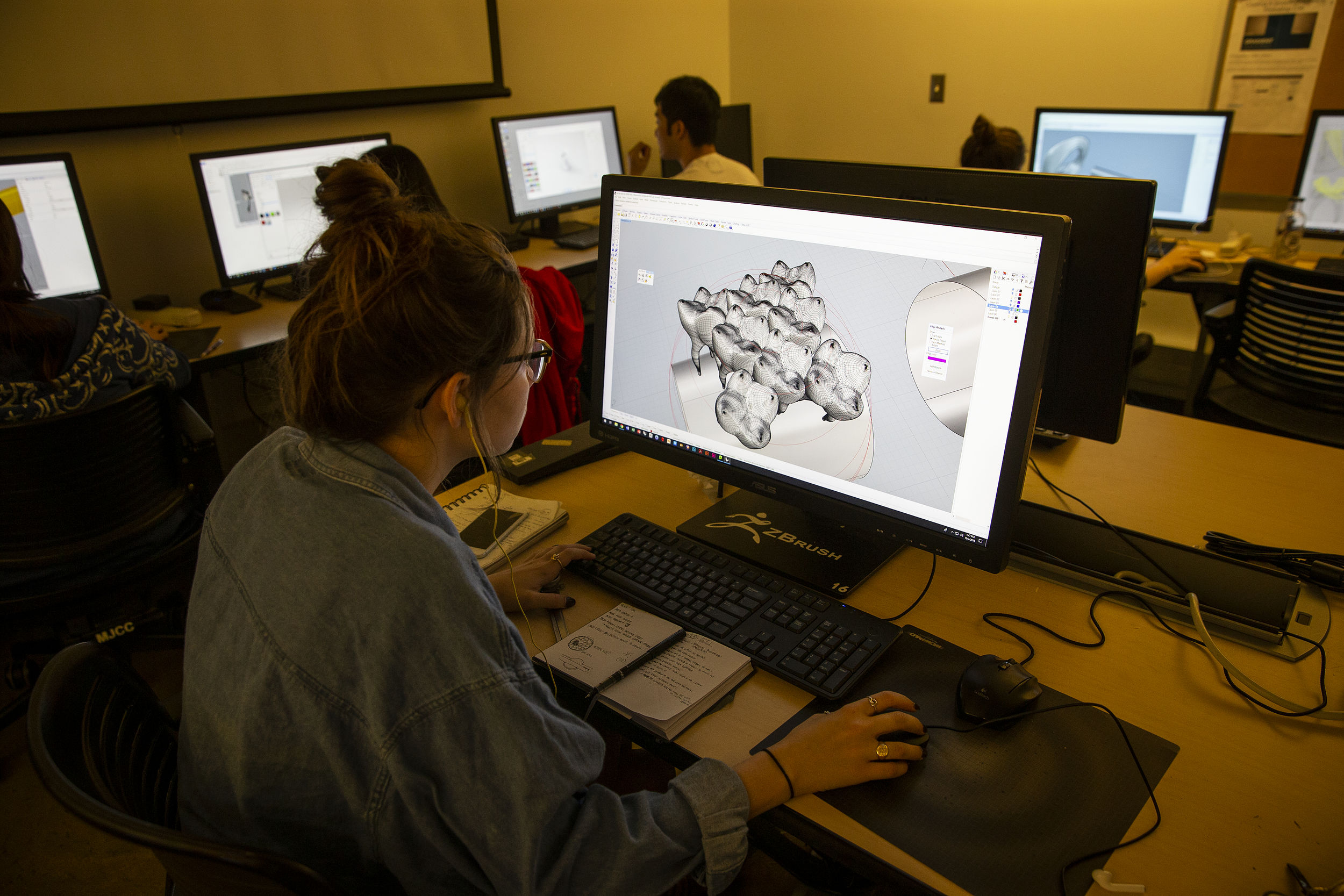 Student designing a 3D jewelry model on a computer.