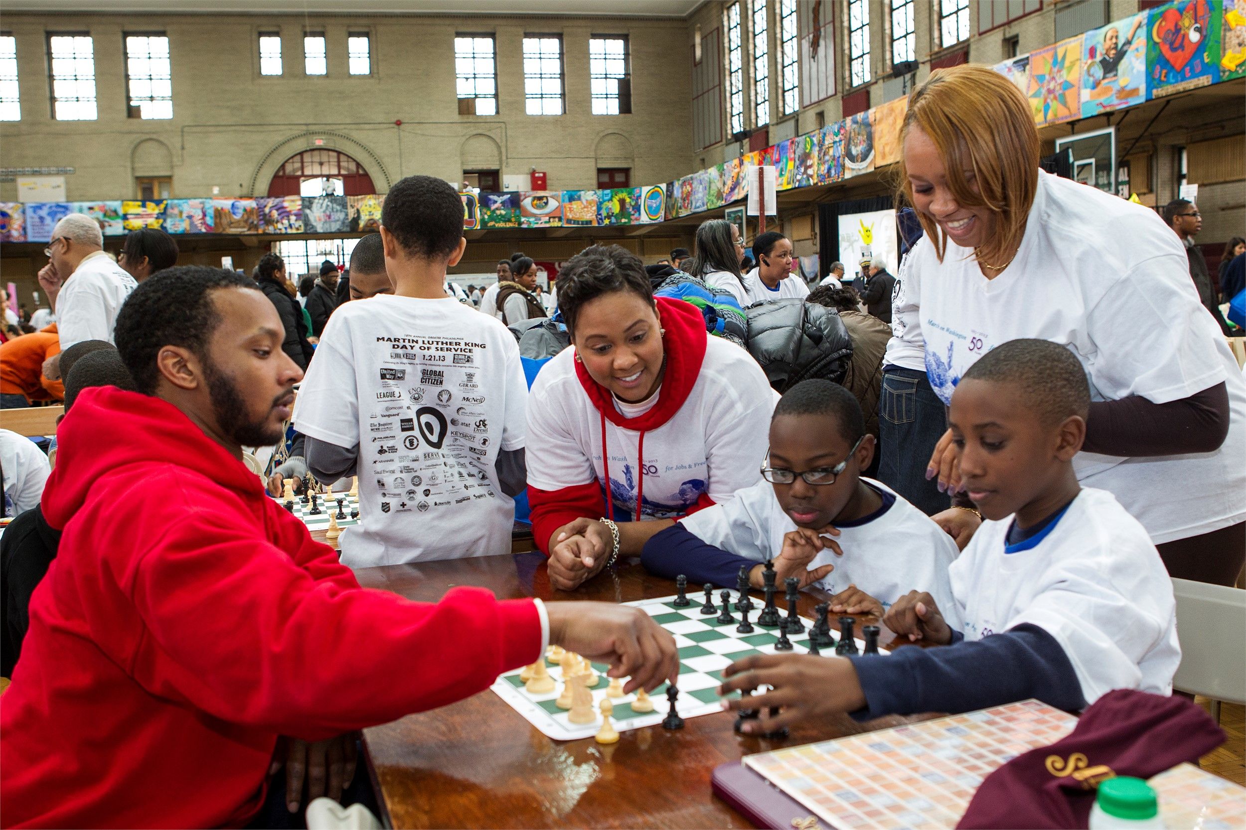 student teachers and their students playing chess together.