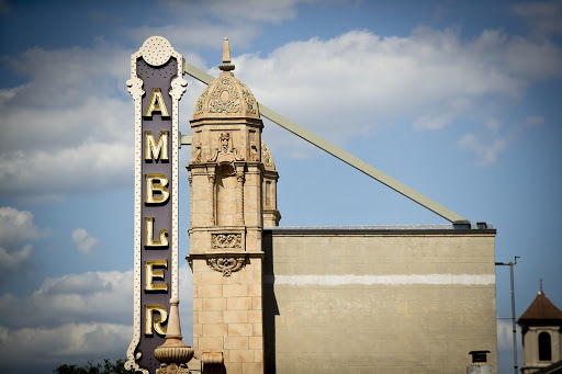 A large vertical "Ambler " marquee with a blue sky behind it.