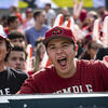 Three students cheering at a football game.