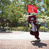 Hooter running through campus with Temple flag