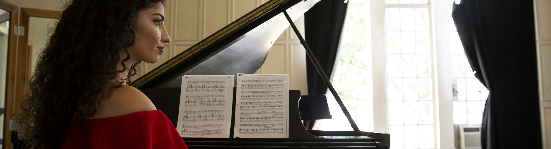 A Boyer student plays piano and sings in one of many rehearsal rooms.